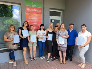 Uczestnicy z certyfikatami przed wejściem do siedziby szkoleniowej.