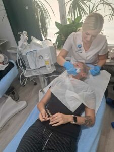 Ćwiczenia obsługi urządzenia kosmetycznego na modelce.