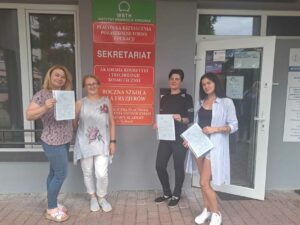 Uczestniczki z certyfikatami przed wejściem do budynku.